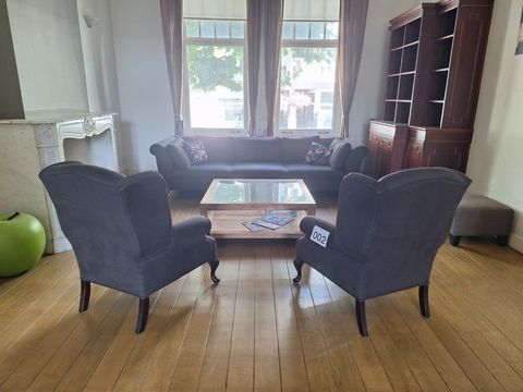 Donkergrijze gestoffeerde driezitsbank met twee bijpassende fauteuils