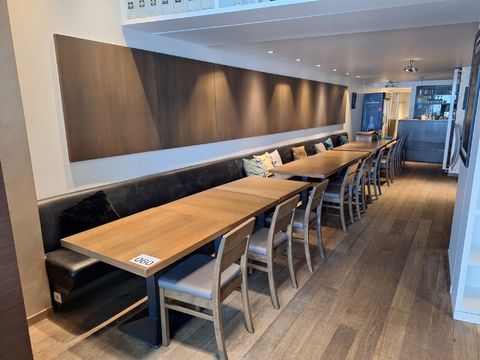 Installation de restauration élégante composée de canapés avec des coussins décoratifs, de tables en bois et de panneaux muraux d'ambiance.